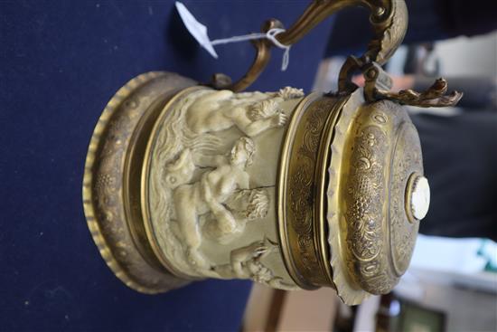 A 19th century German ormolu mounted ivory tankard, carved in relief with a frieze of tritons and nude bathers